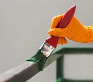 Hand mit grünem Pinsel bemalt Doppelstabzaun